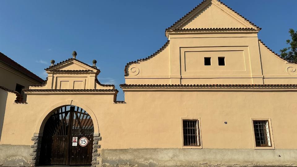 Historická brána školního statku ve Vědomicích s barokním štítem